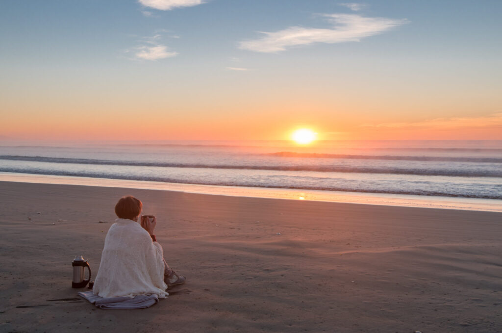Frau am Strand bei Sonnenuntergang von kiravolkov in AdobeStock