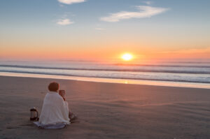 Frau am Strand bei Sonnenuntergang von kiravolkov in AdobeStock